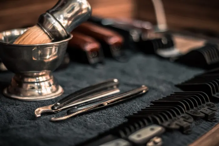 Shaving bowl, brush and straight razors laid out on a towel