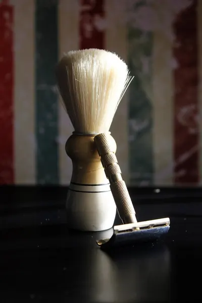Shaving brush and safety razor on a dark counter