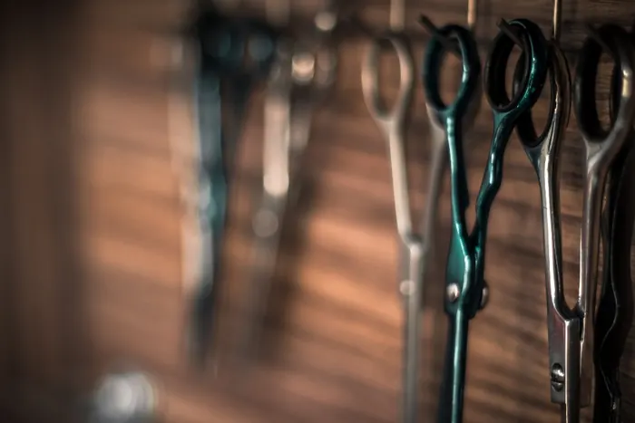 Barber shears hanging against a wood wall