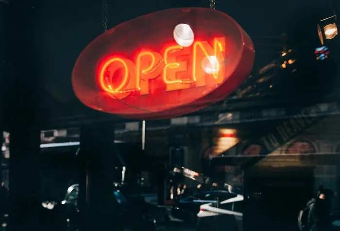 A glowing red OPEN sign in the shop window