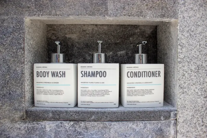 Shampoo and conditioner bottles in a stone niche